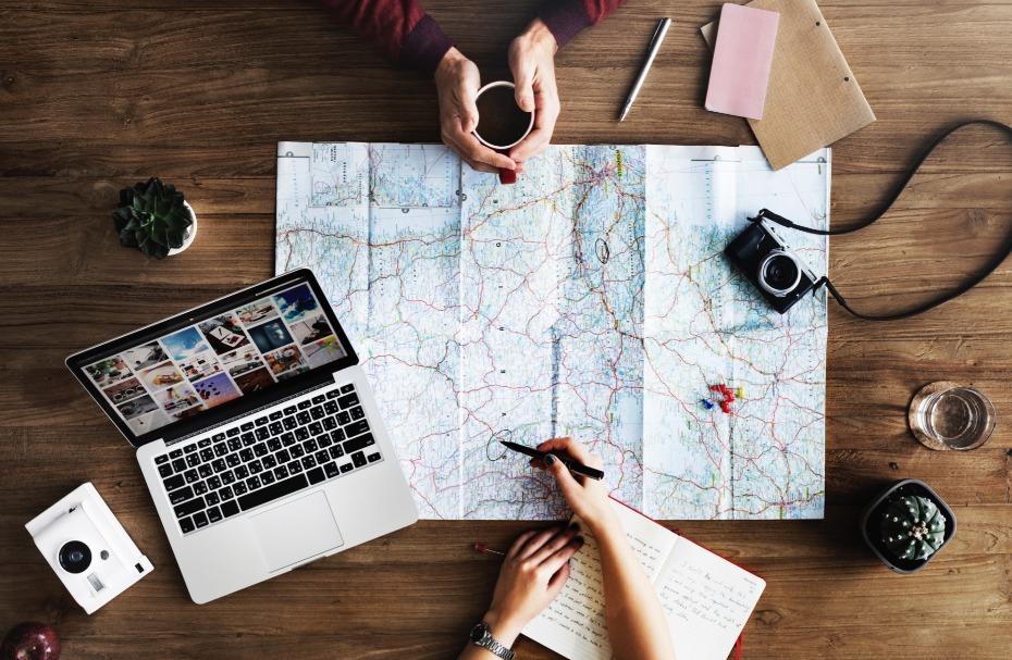 Notebook and travel planning materials on a desk